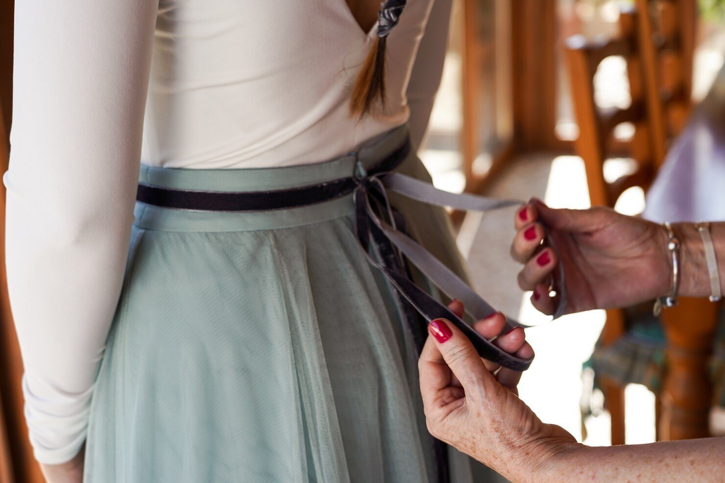 closeup-shot-mother-helping-bride-arrange-wedding-dress_181624-26540